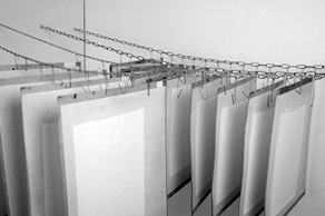 Paperiarkit ovat kiinni kuivauslevyissä, jotka riippuvat kuivausketjuissa.